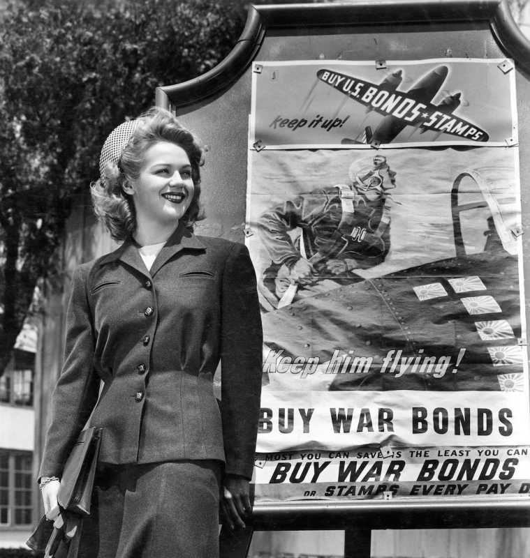 Wanita di hadapan papan tanda War Bonds pada tahun 1943