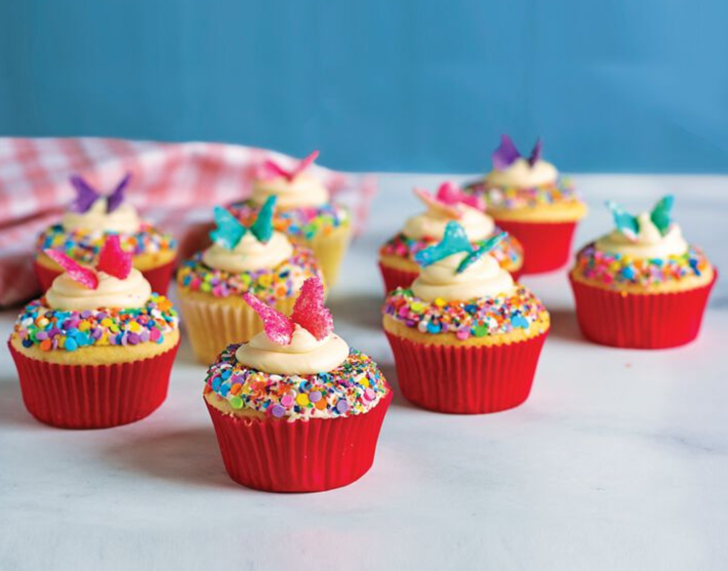 Cupcakes com granulado de arco-íris e enfeite de borboleta