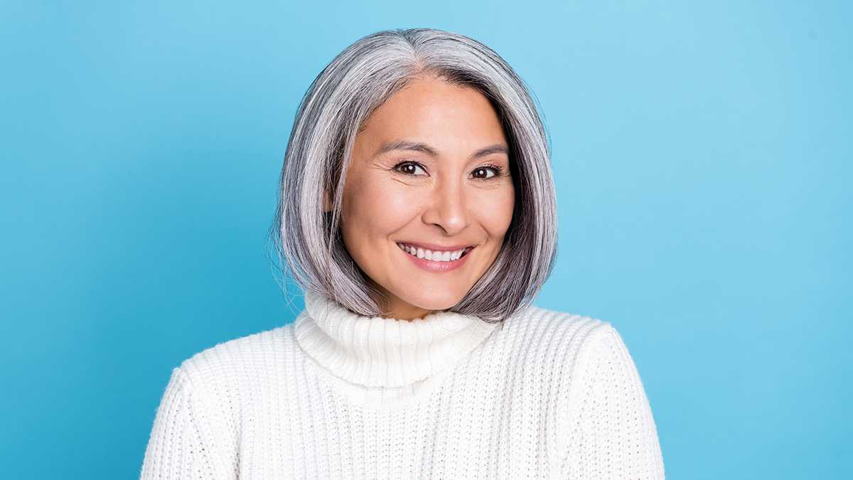 Retrato de uma mulher asiática que está ficando grisalha graciosamente