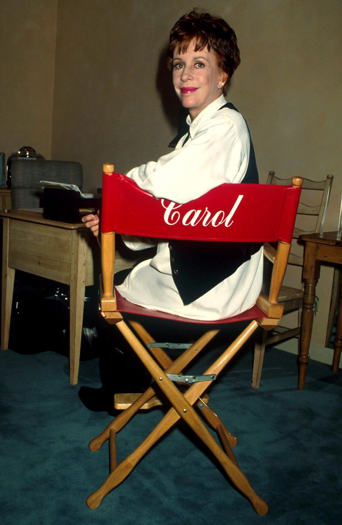 Carol Burnett sentada em uma cadeira com o nome dela
