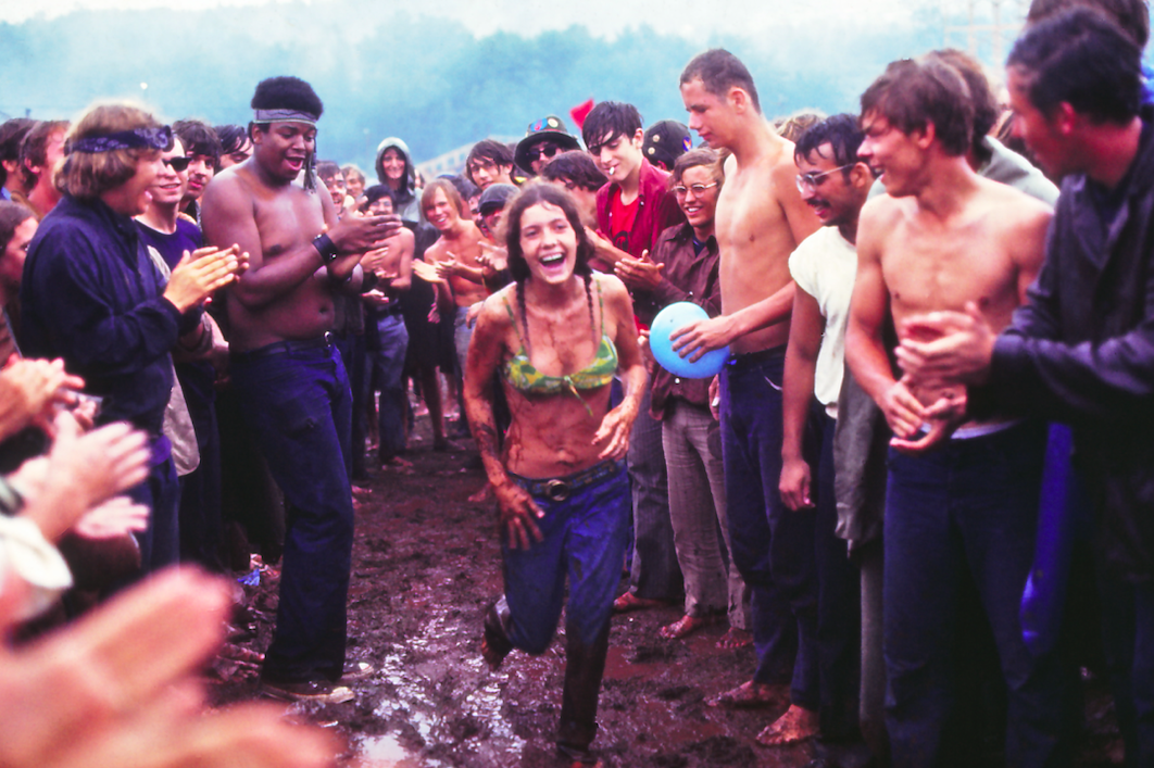 Žena běží přes bahno na Woodstock