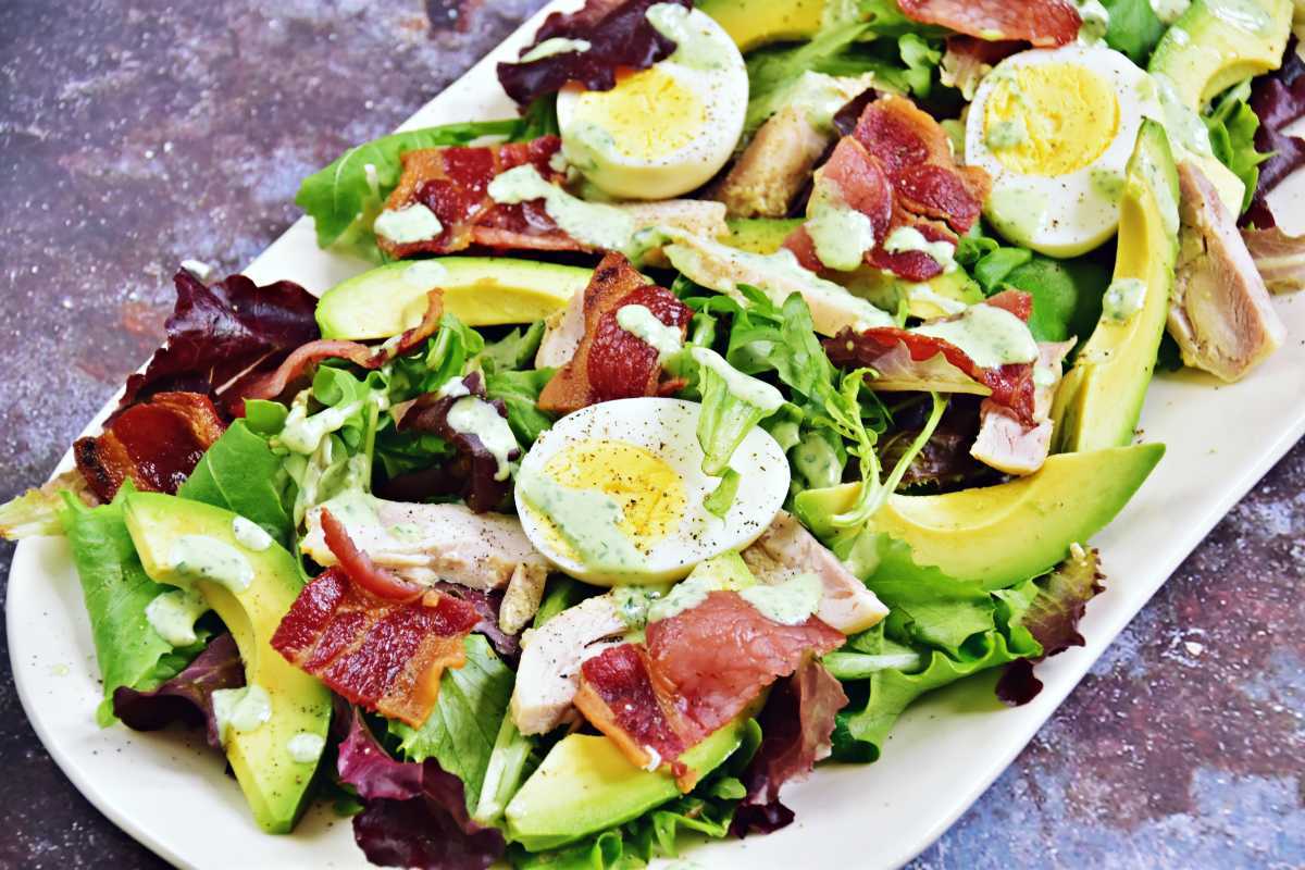Stor salat med salat, bacon, hårdkogte æg og avocado